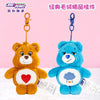 A golden brown Care Bears plush toy with a red heart on its chest and a blue Care Bears plush toy with a purple cloud on its 