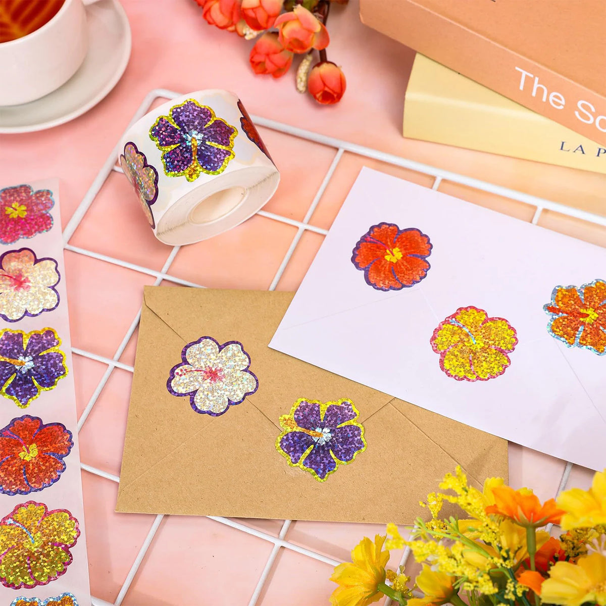 A collection of colorful glitter flower round stickers on a white background, next to a brown envelope and a box.
