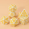 A set of seven polyhedral dice in white and orange geometric patterns resting on a light beige surface.