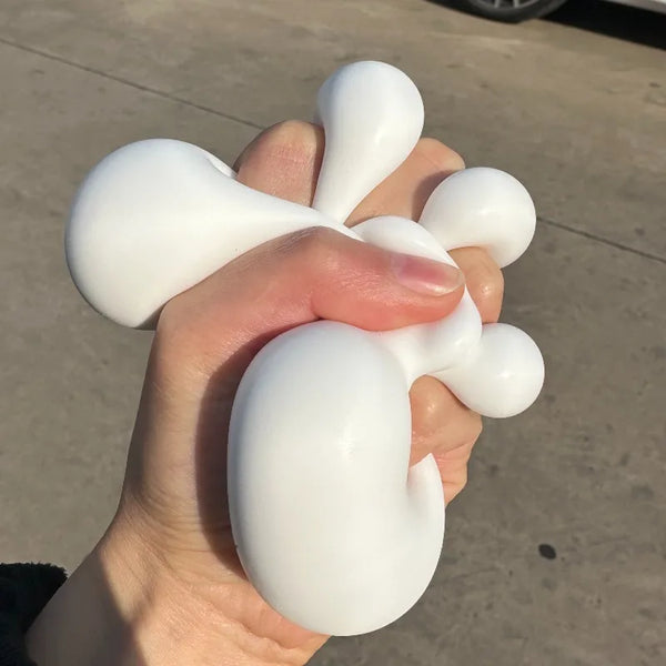 Eine Hand drückt ein weißes, weiches Milch-Tofu-Stressabbau-Fidget-Spielzeug.