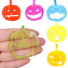 A set of orange, pink, and blue plastic Halloween pumpkin face molds for party favors.