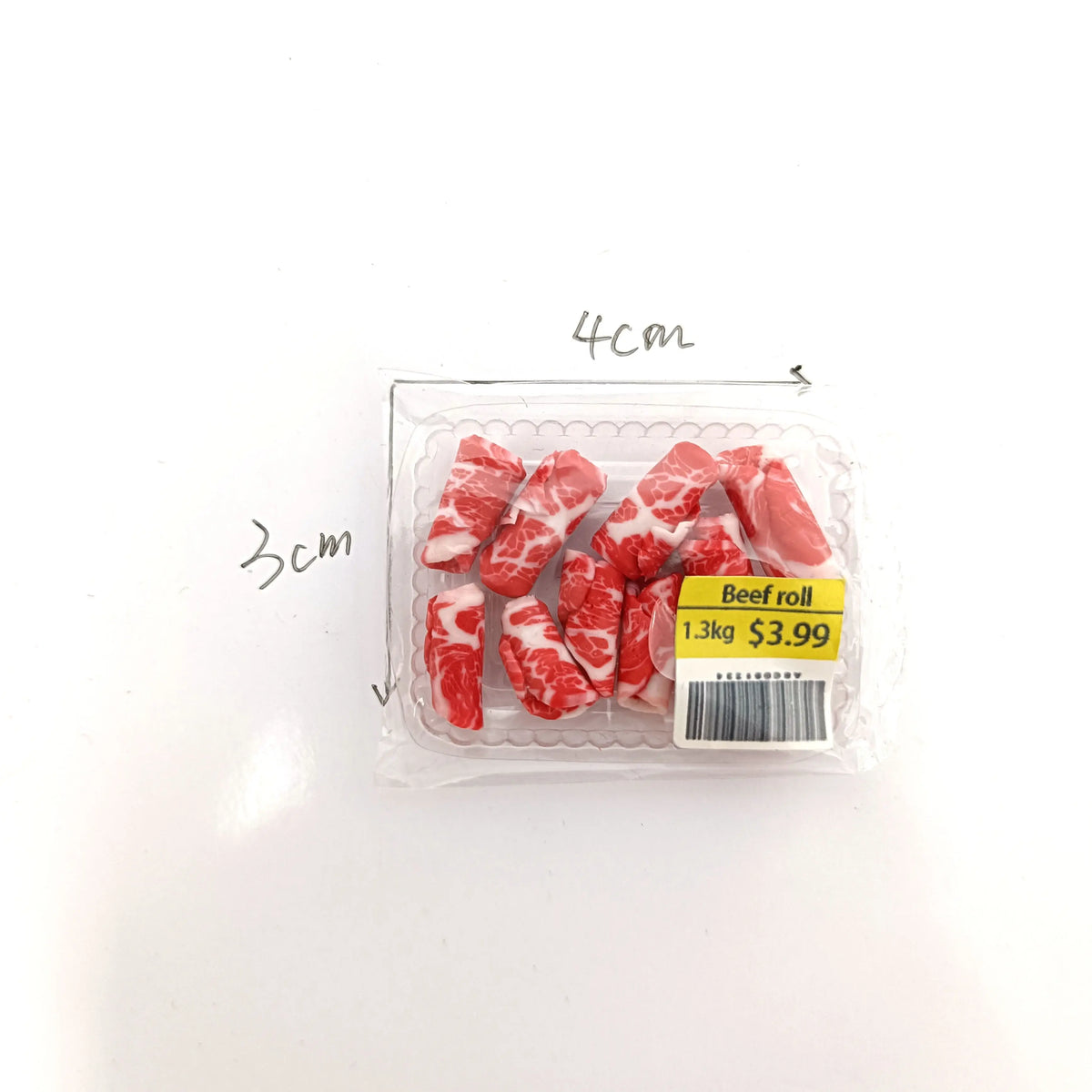 A clear plastic package containing realistic beef roll meat pieces, with dimensions marked.
