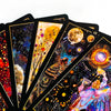 A close-up of a deck of illuminated tarot cards featuring cosmic and mystical imagery.