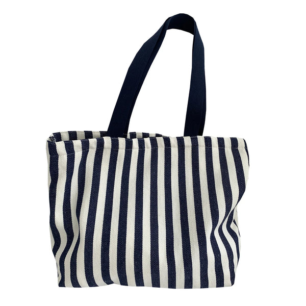 A striped canvas shoulder tote bag with navy and off-white vertical stripes.