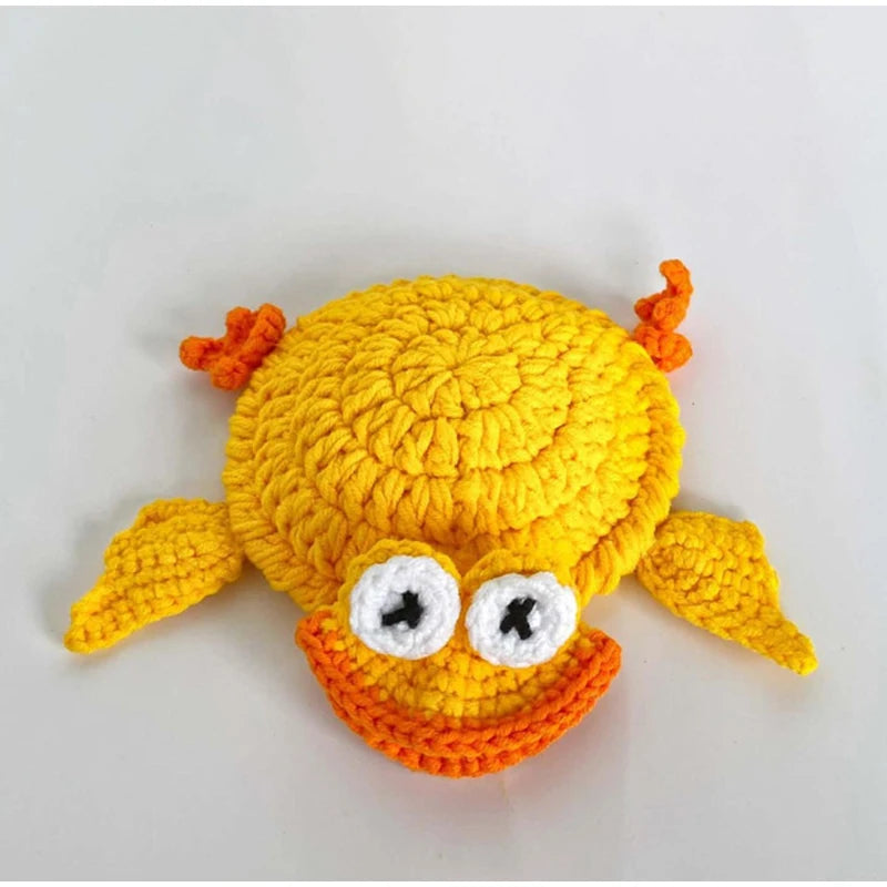 Handmade crochet lizard coaster with orange and yellow colors and large white eyes