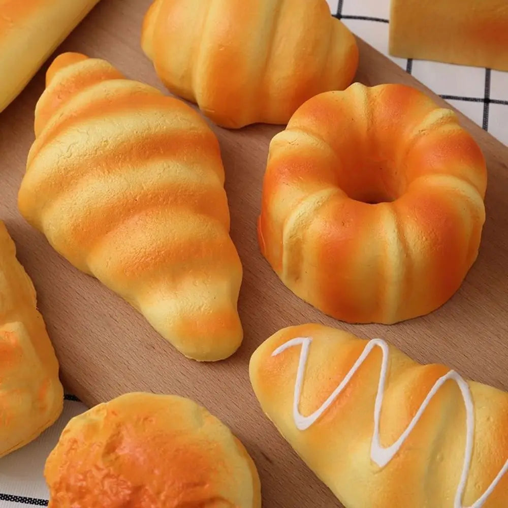 A collection of realistic bread squeeze toys in various shapes and colors, showing different textures and squeezable forms.