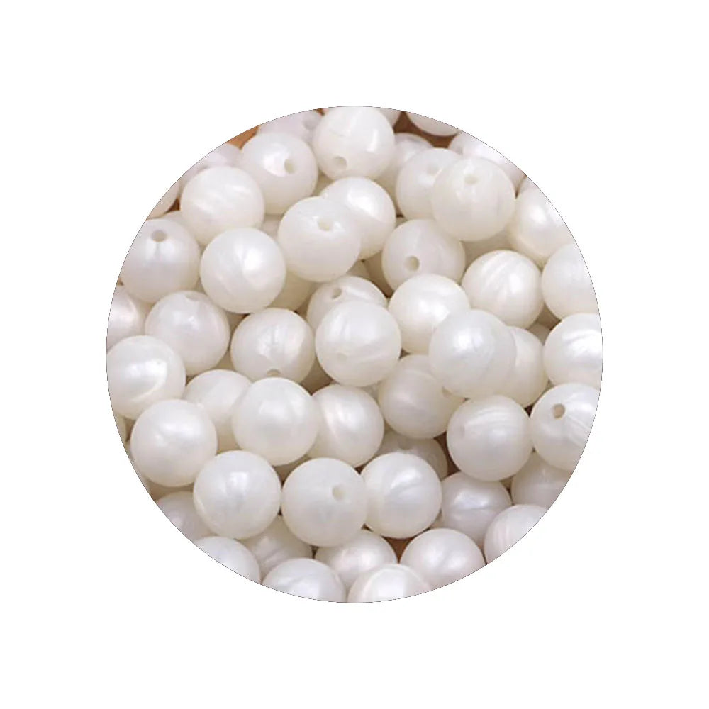 A circular arrangement of white silicone beads in various sizes for DIY jewelry making