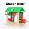 A green wooden station block playset with an arched entrance and decorative elements for railway play.