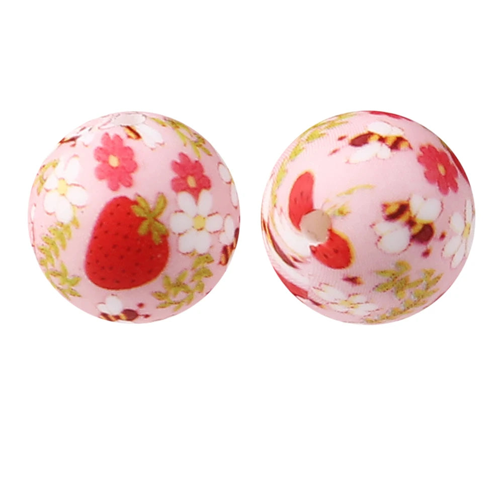 A pair of pink silicone beads decorated with red strawberries and white flowers for jewelry making