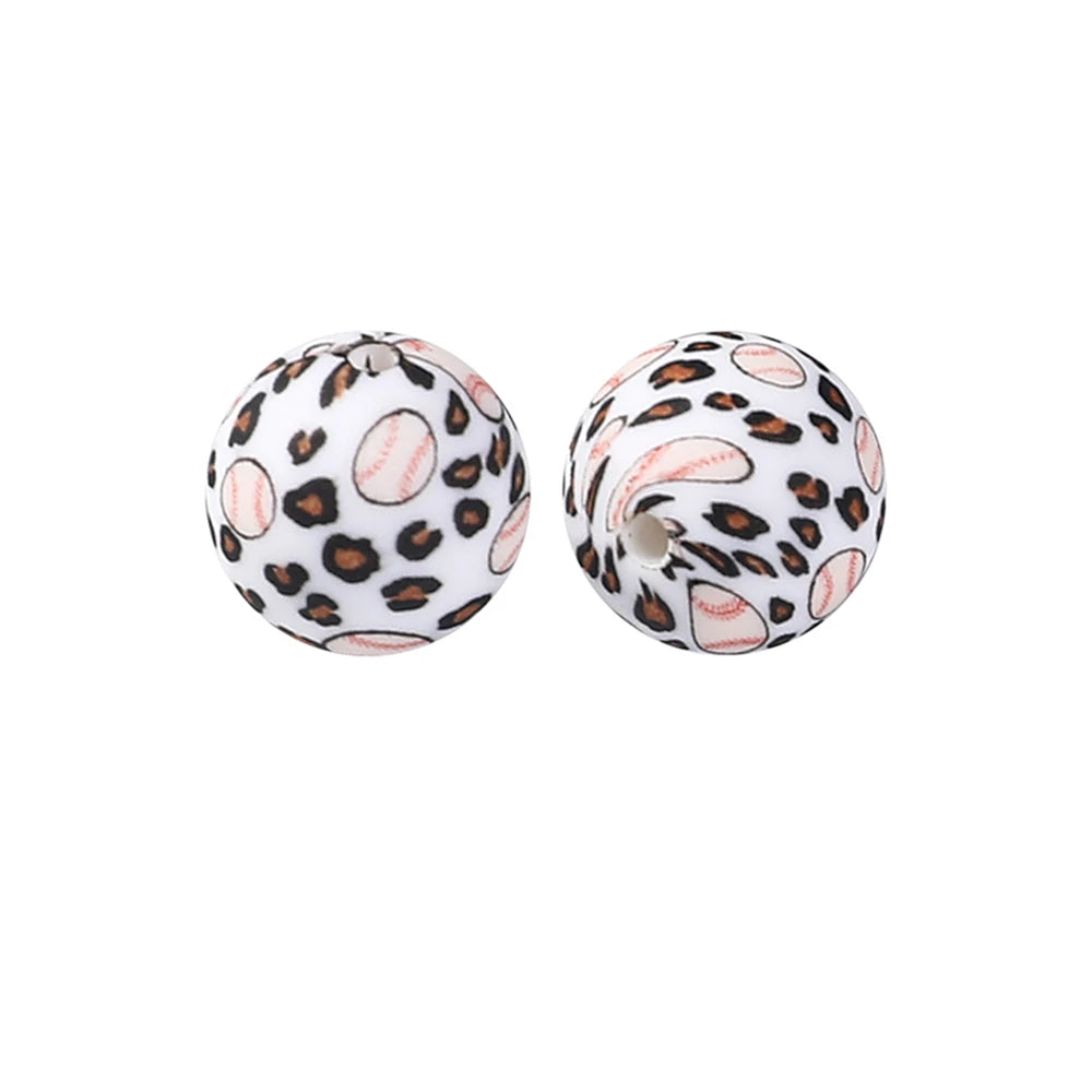 Two spherical silicone beads with a leopard print design and a pink center, used for jewelry making.