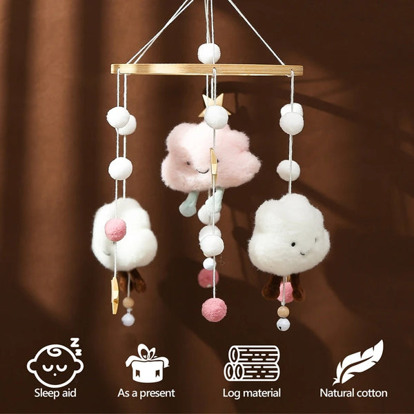 Wooden rattles and mobile pendant featuring soft white and pink cotton clouds hanging from a wooden bar
