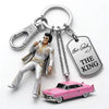 A silver keychain featuring a figurine of Elvis Presley in a suit and sunglasses.