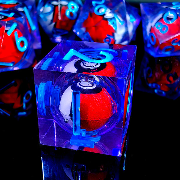 A close-up view of a set of polyhedral dice in various colors, including blue and red, resting on a reflective surface.
