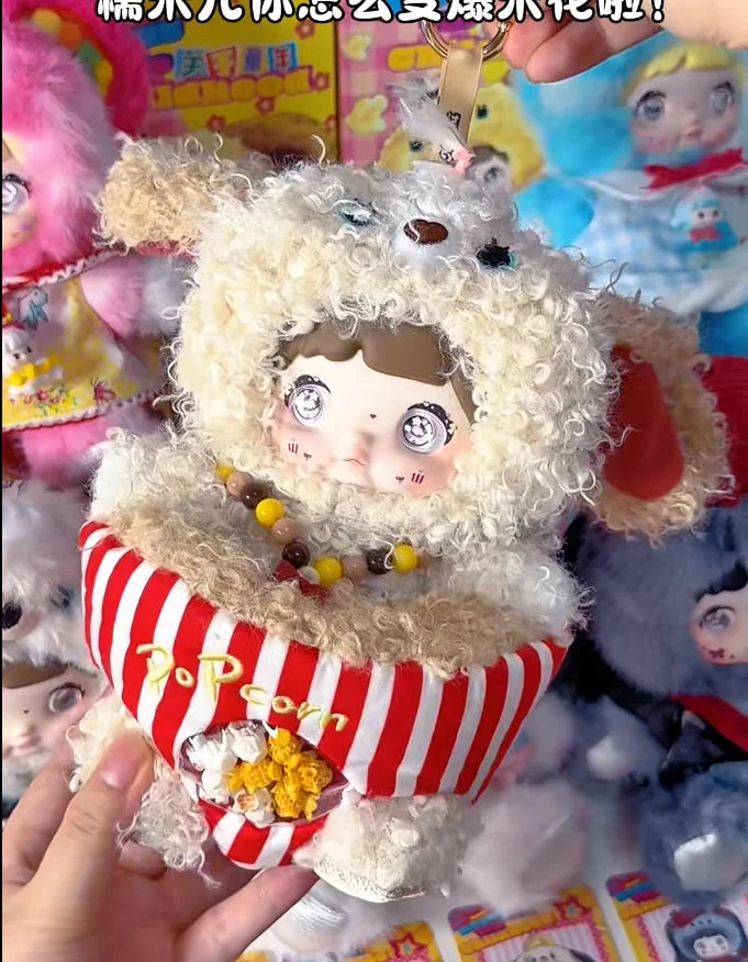 A fluffy white plush doll wearing a hood and striped clothing is held in a hand.
