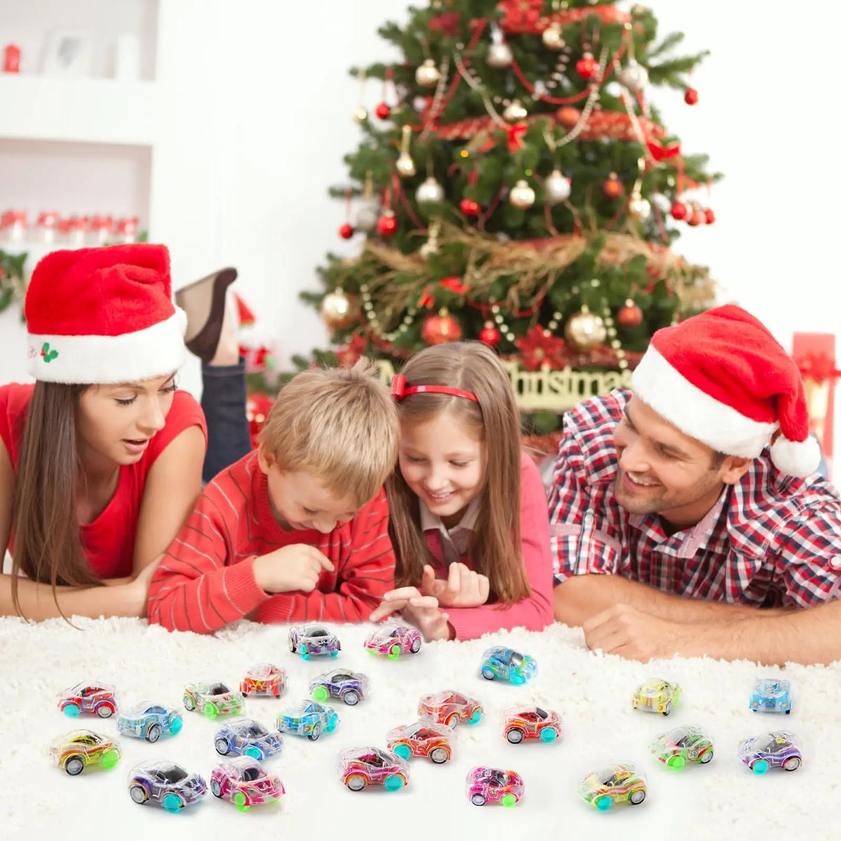 A family is playing with a 5-pack of mini pull-back race cars on a white surface in front of a Christmas tree.