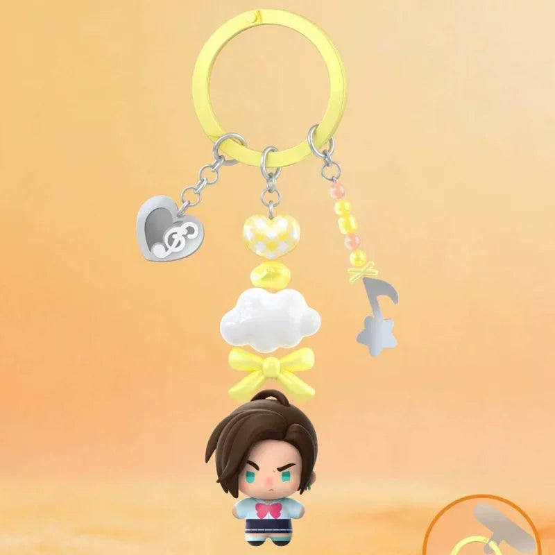 A blind box figure of a character with dark hair and blue eyes is displayed below a yellow hoop charm.