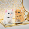 A white and an orange plush cat toy displayed in a gold geometric frame.