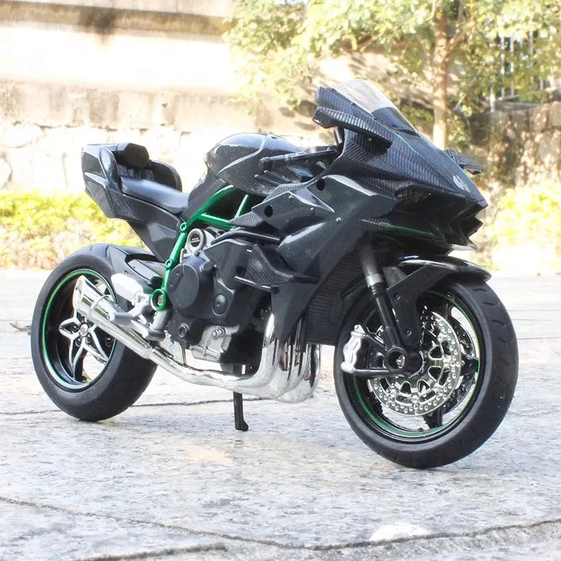 A black 1:12 scale diecast sport motorcycle model with shock absorption on a paved surface.