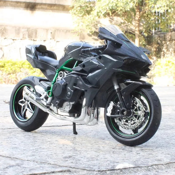 A black 1:12 scale diecast sport motorcycle model with shock absorption on a paved surface.