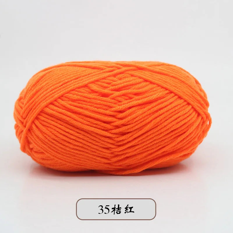 A ball of bright orange pre-dyed milk cotton yarn used for knitting and crochet.