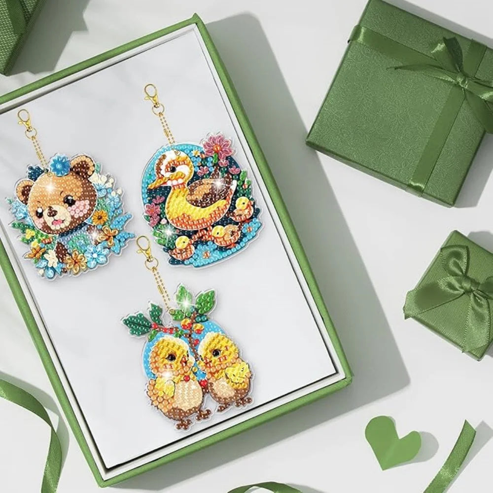 A diamond painting kit featuring three owl-themed charms on a green display card.