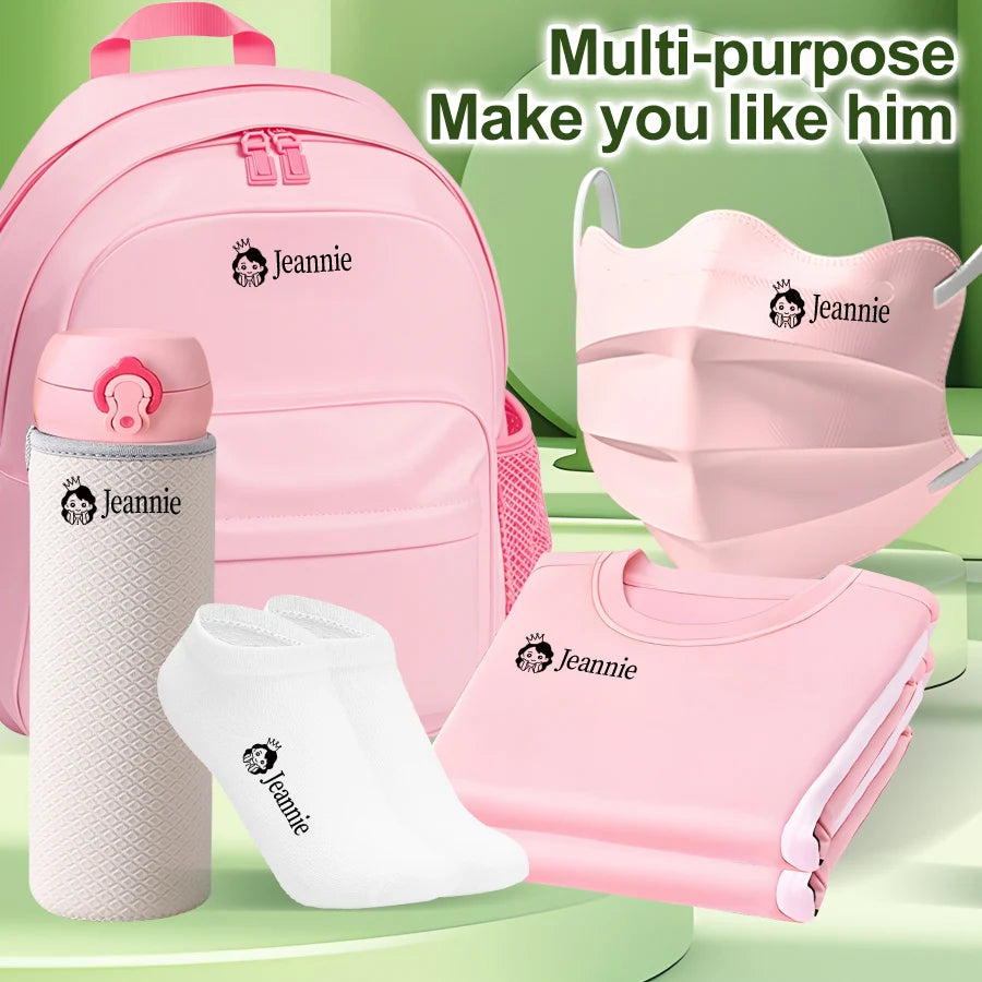 A pink backpack, face mask, and clothing item featuring the name Jeannie stamp.