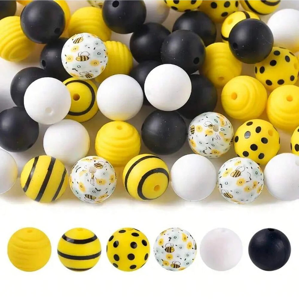 A collection of colorful 3D bee silicone beads in yellow, black, and white for DIY crafts.