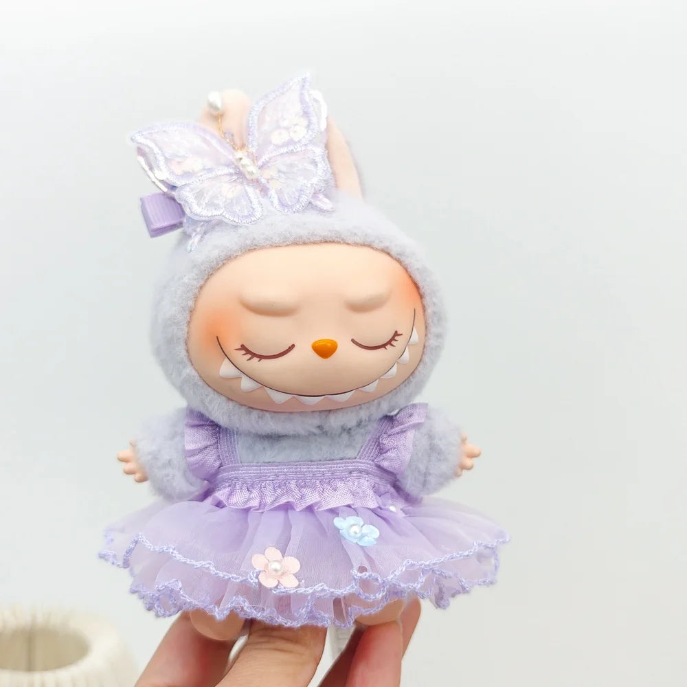 A cute, light purple doll wearing a fluffy lavender hat and a matching dress with lace details.