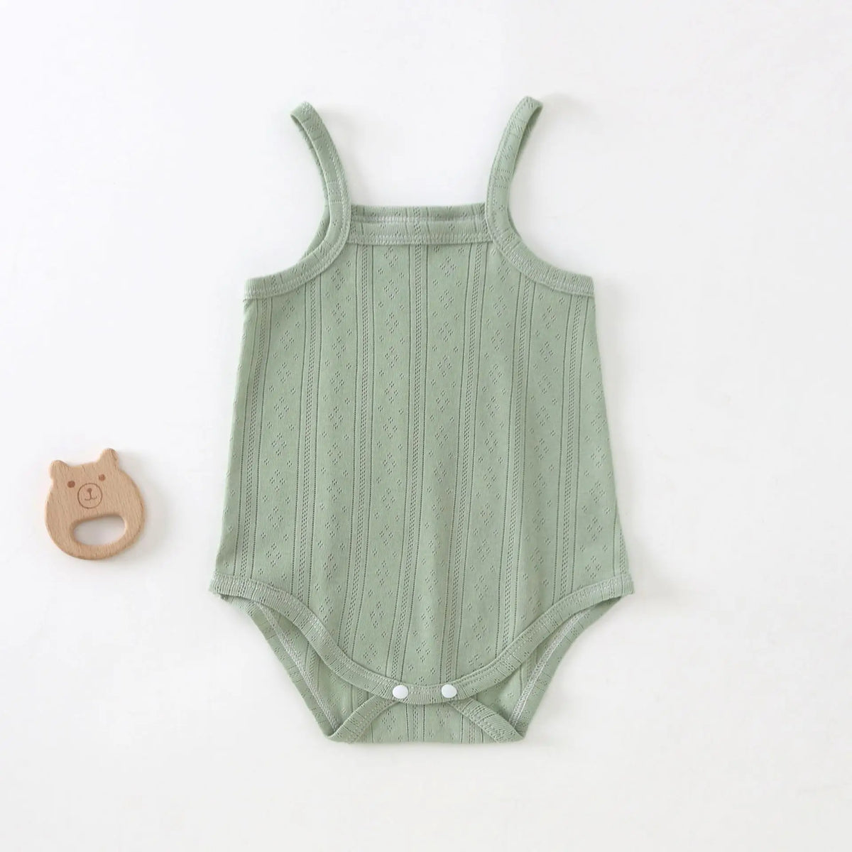 A light sage green lightweight cotton strappy romper for babies with a textured vertical pattern.