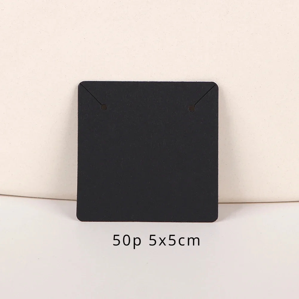 A black square jewelry display card with rounded corners is shown on a light background.