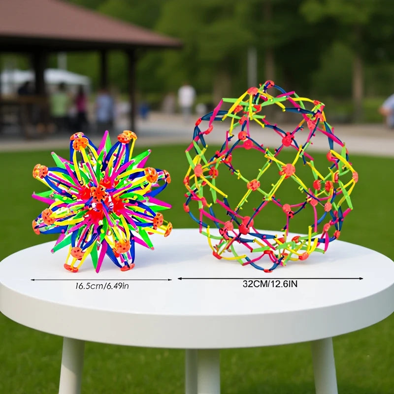 A colorful expandable magic ball stress relief toy with a mesh structure displayed on a white table.