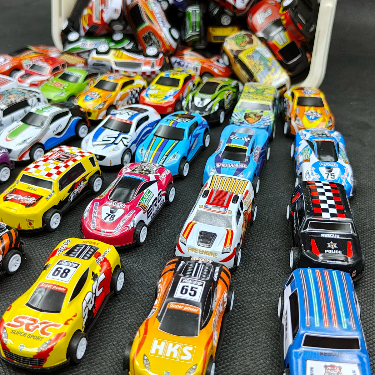 A collection of die-cast mini racing cars in various colors and liveries displayed in a white storage box.