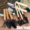 A set of three mini gardening tools with wooden handles and black blades resting on brown burlap fabric.
