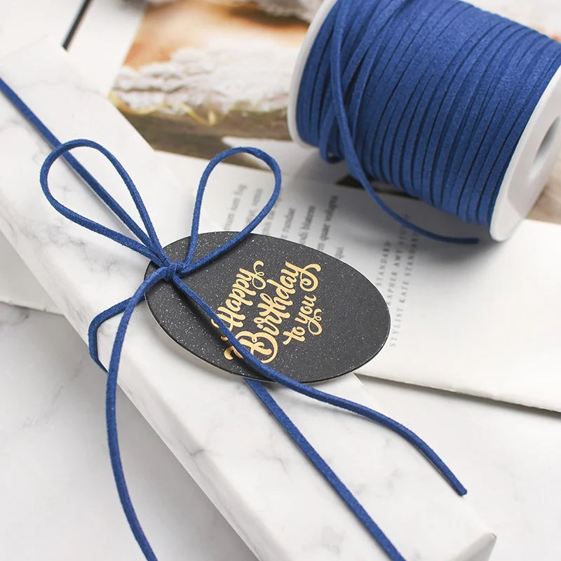 A roll of blue braided ribbon used for crafting and gift wrapping, tied with a black tag.
