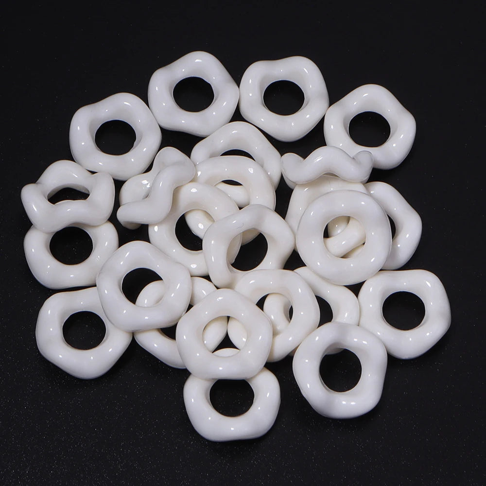 A collection of white acrylic doughnut spacer beads for jewelry making