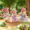 A set of Sylvanian Families deer figures with pink and white floral clothing in a grassy outdoor setting.