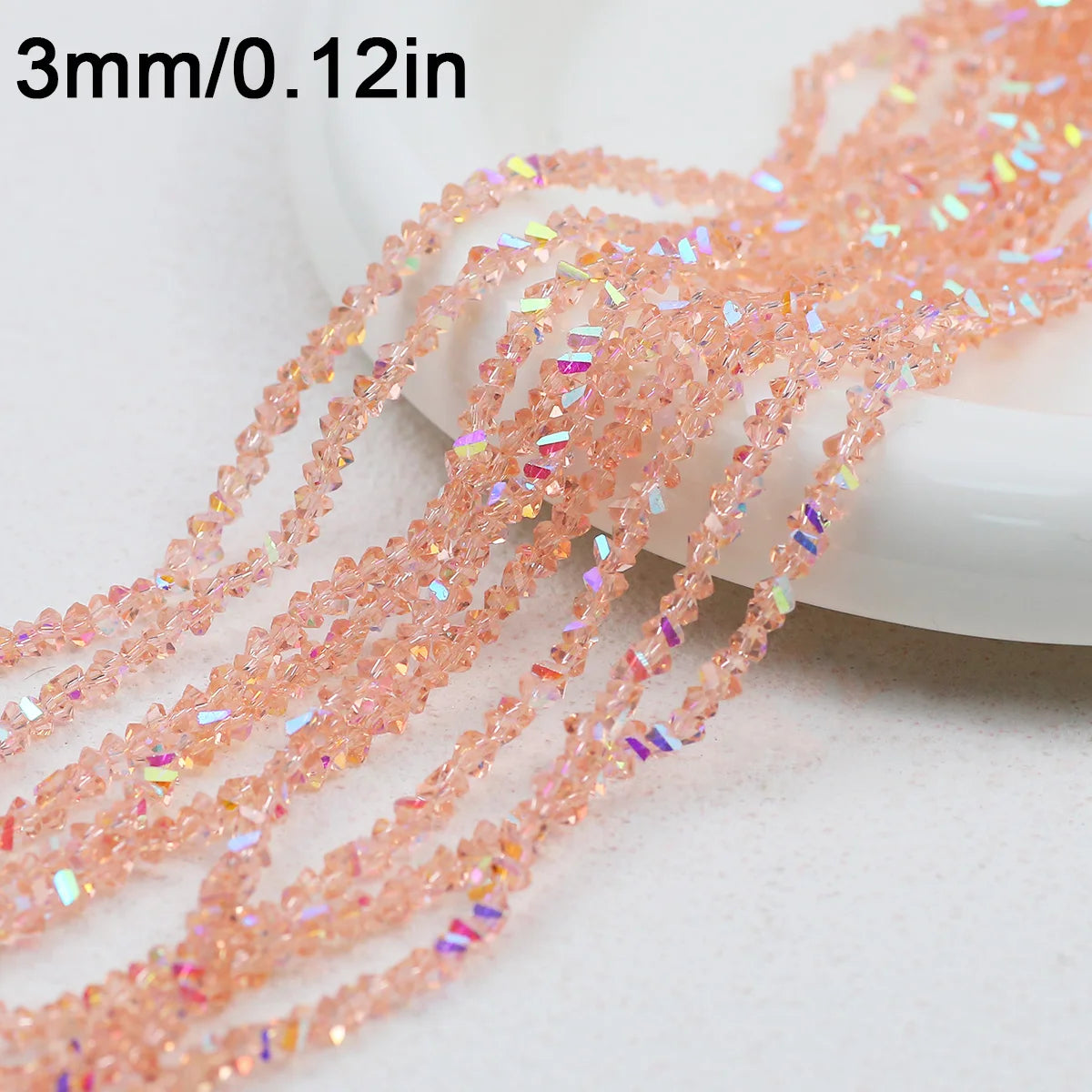 Pink crystal triangle beads measuring 3mm or 0.12 inches arranged on a white surface.