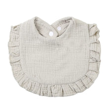 A light beige ruffled muslin cotton baby bib with an adjustable snap closure.
