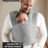A man is wearing a grey knitted fabric baby carrier while holding a baby, demonstrating its adjustable fit for various body s