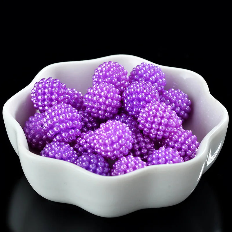 A white bowl filled with purple acrylic pearl beads for jewelry making