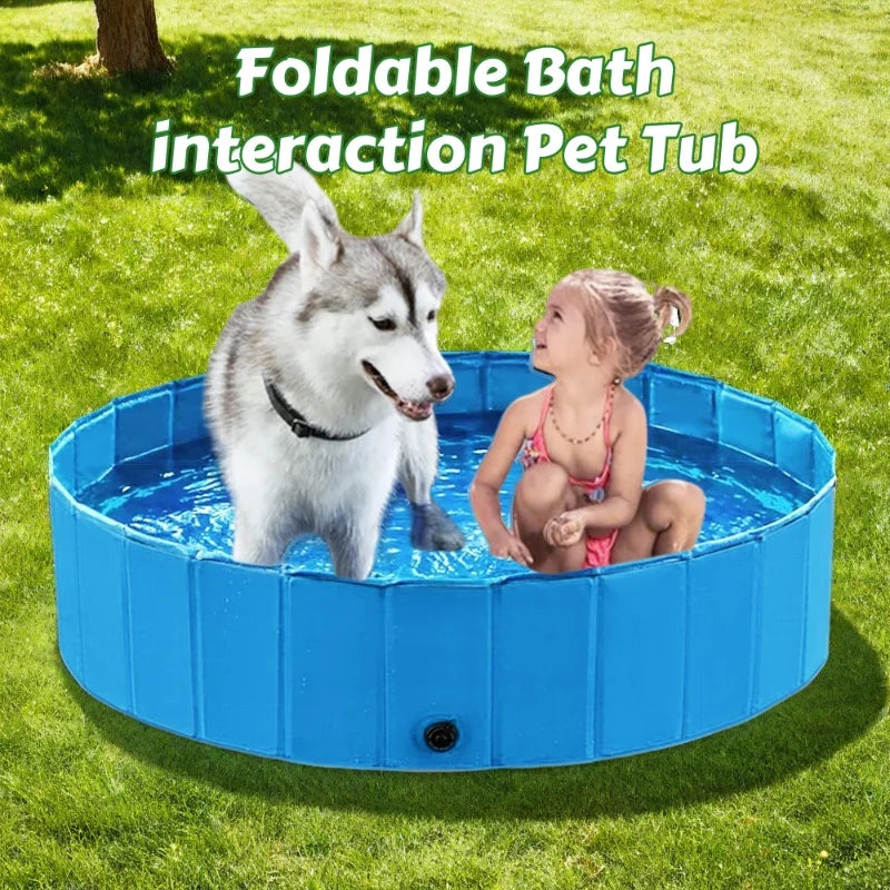 A dog and a young girl interacting with a blue foldable pet tub outdoors on the grass.