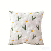 White faux fur pillow covers with embroidered green and yellow daisy designs.