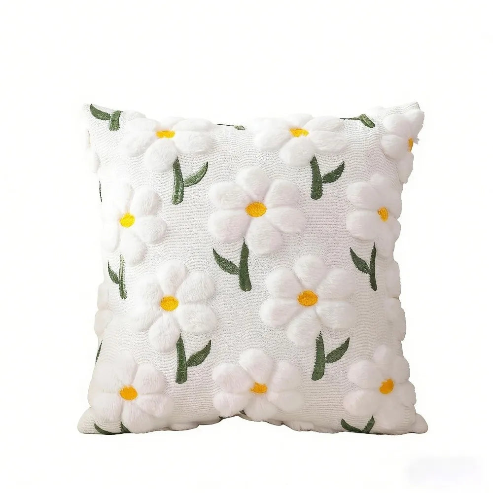White faux fur pillow covers with embroidered green and yellow daisy designs.