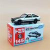 A black and white die-cast sports car model is displayed next to its packaging box.