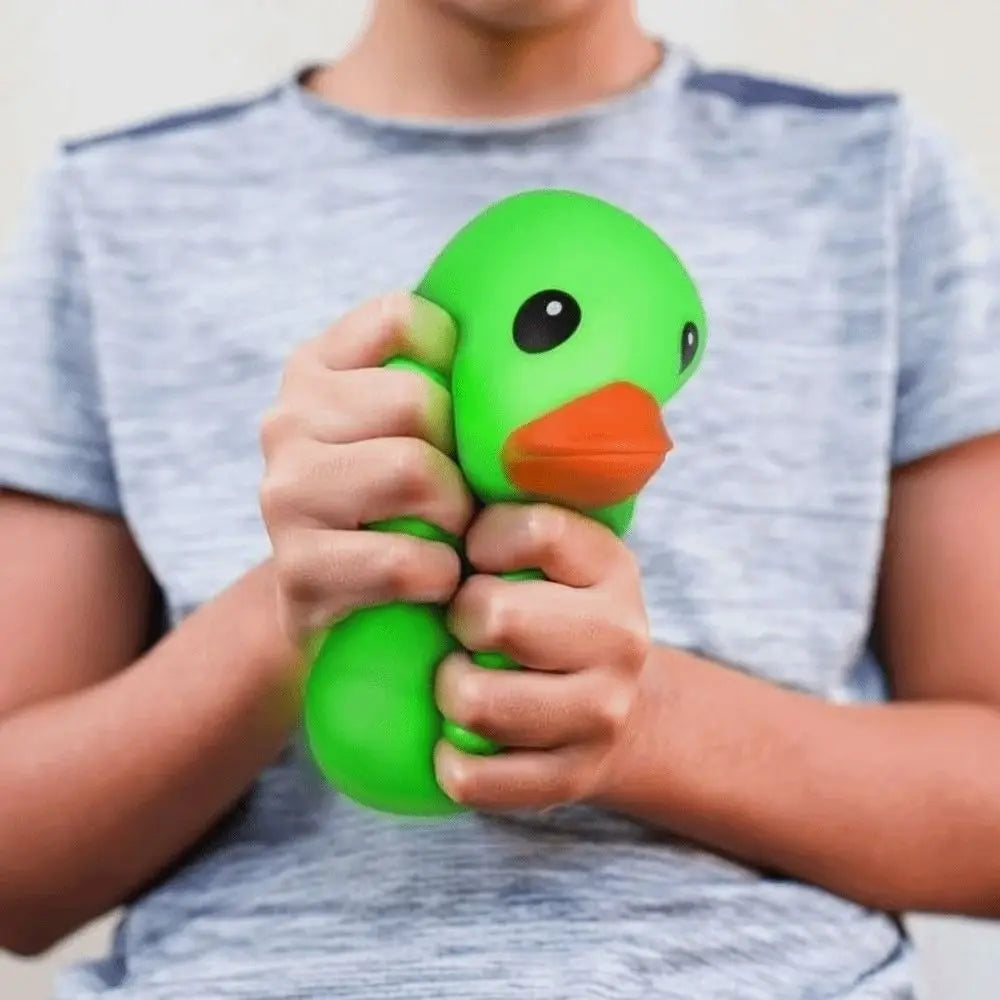 A person is holding a bright green squeeze duck stress relief toy against a gray t-shirt.