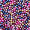A close-up of colorful imitation pearl beads in various shades of pink, purple, blue, and gold.