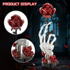 A building kit featuring a skeleton hand and red rose elements displayed on a dark background.