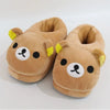 A pair of brown Rilakkuma plush indoor slippers with yellow accents.