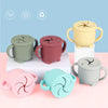 A collection of BPA-free silicone snack cups in various pastel colors, including green, pink, purple, and beige.