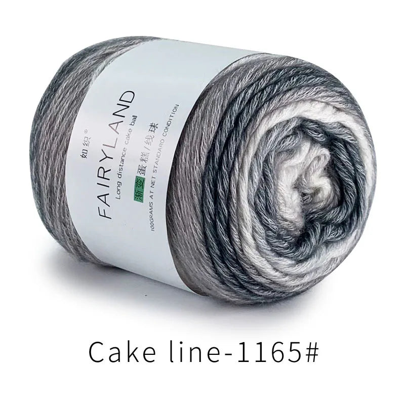 A skein of grey and white gradient cotton-wool yarn labeled Fairyland Cake ball for knitting and crochet.